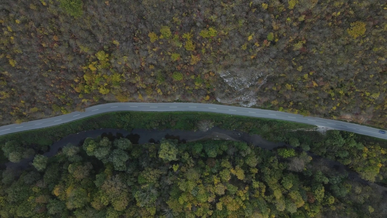 汽车行驶在道路上，在秋天的日子重型车辆运输旅行汽车驾驶假期的概念上，沥青自上而下的空中无人机视图视频素材