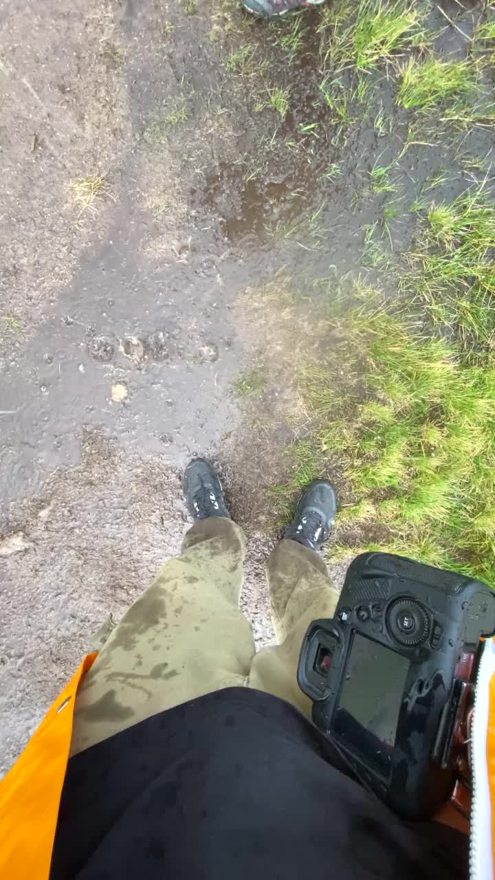 穿着黄色雨衣的女人在雨天沿着岩石小道走视频素材