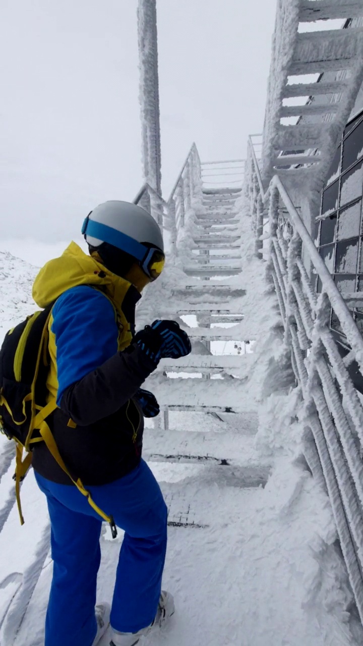 女滑雪者从结冰的楼梯上爬上去看风景视频素材