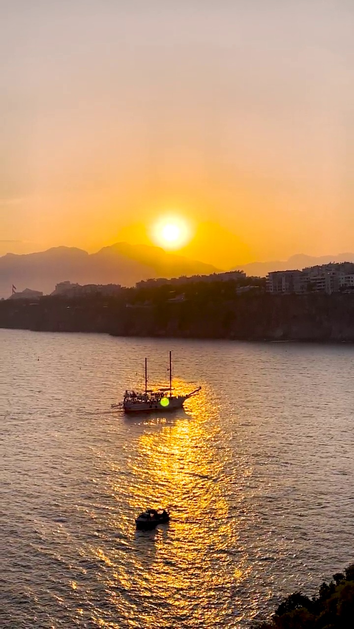 船只航行在安塔利亚港，夕阳下的地中海和山脉视频素材