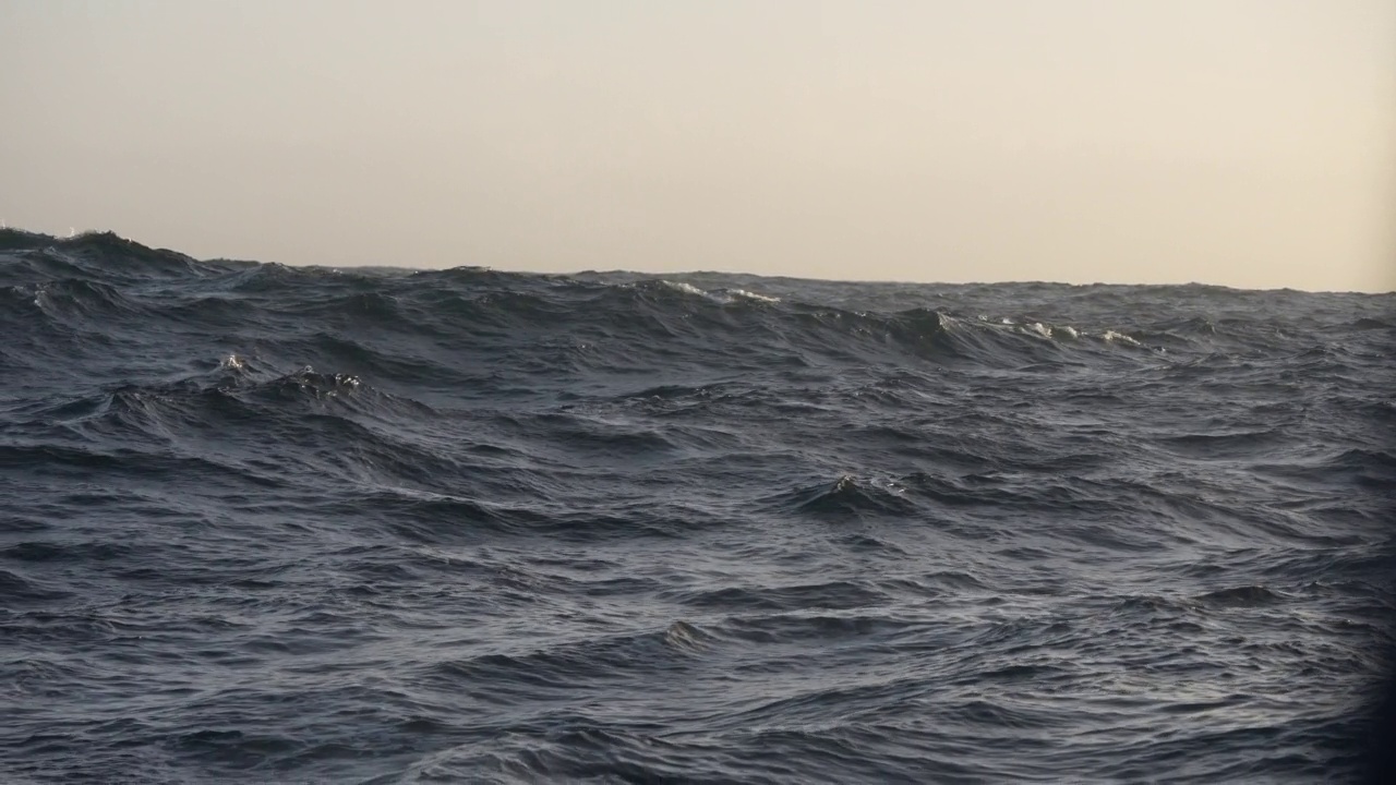 波涛汹涌的海面上，有一艘船从开阔的海面上驶过视频素材