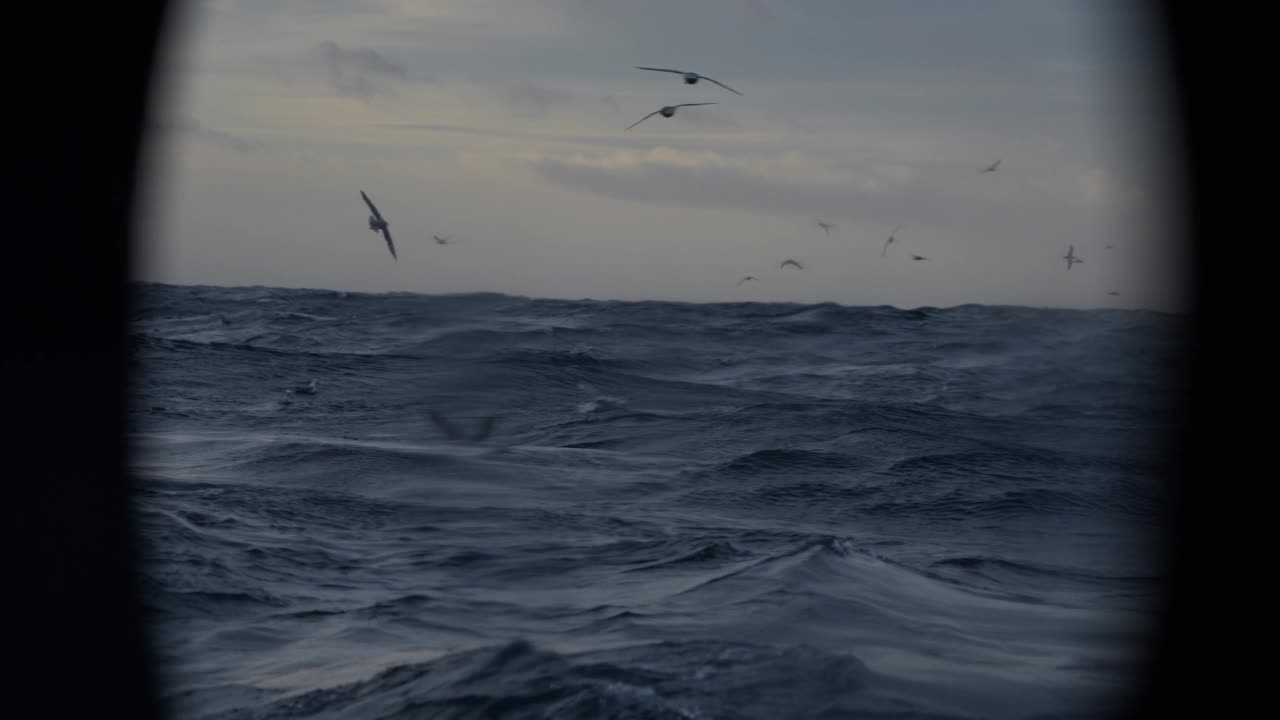 夕阳落在波涛汹涌的海面上，从一艘小船上驶过开阔的大海视频素材