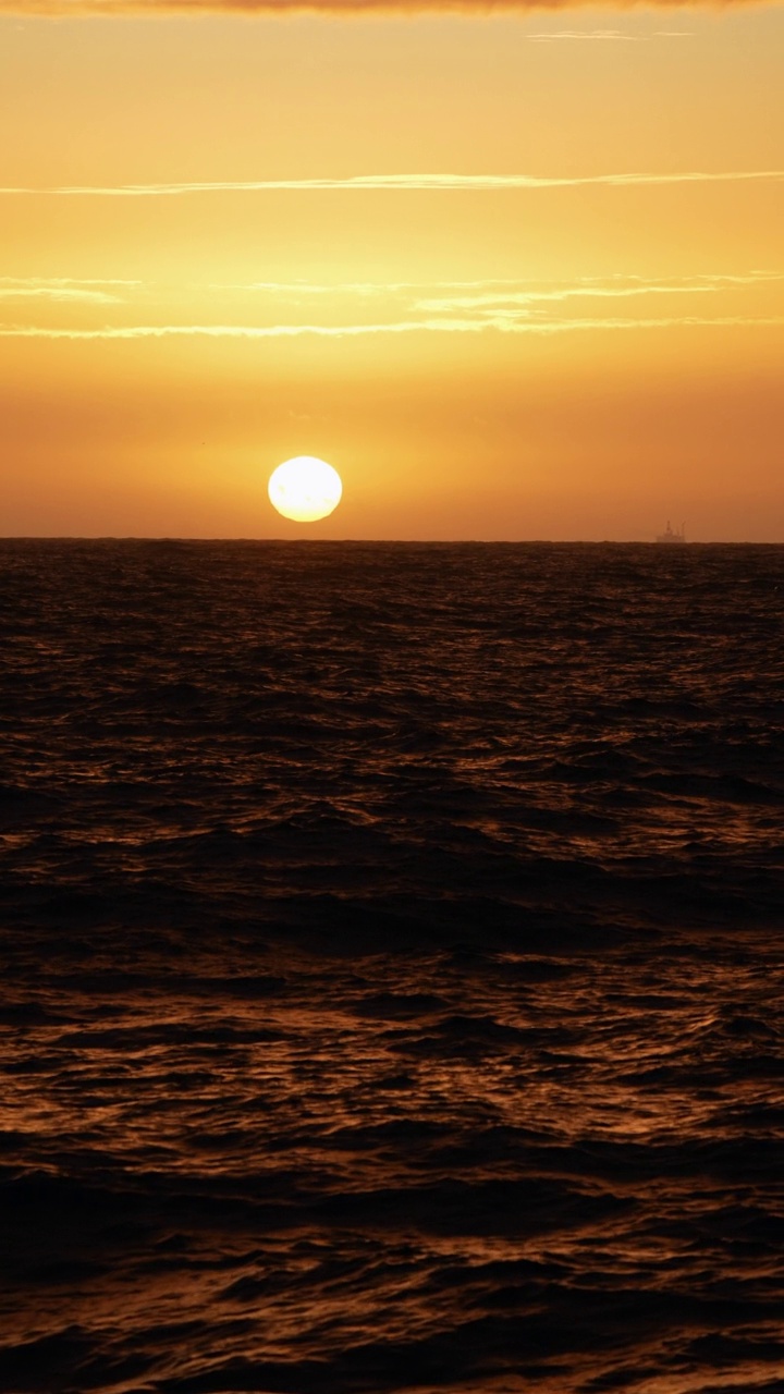 夕阳落在波涛汹涌的海面上，从一艘小船上驶过开阔的大海视频素材