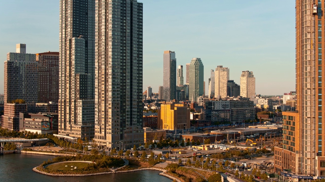 皇后区猎人角(Hunters Point)的一幢新住宅楼。建筑院子，可以看到长岛市的摩天大楼和河边的景色。航拍视频与平移相机运动。视频素材