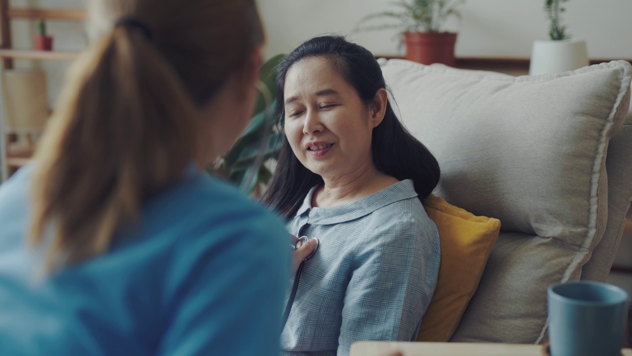 专业的女医生在家里的客厅探望病人。视频素材