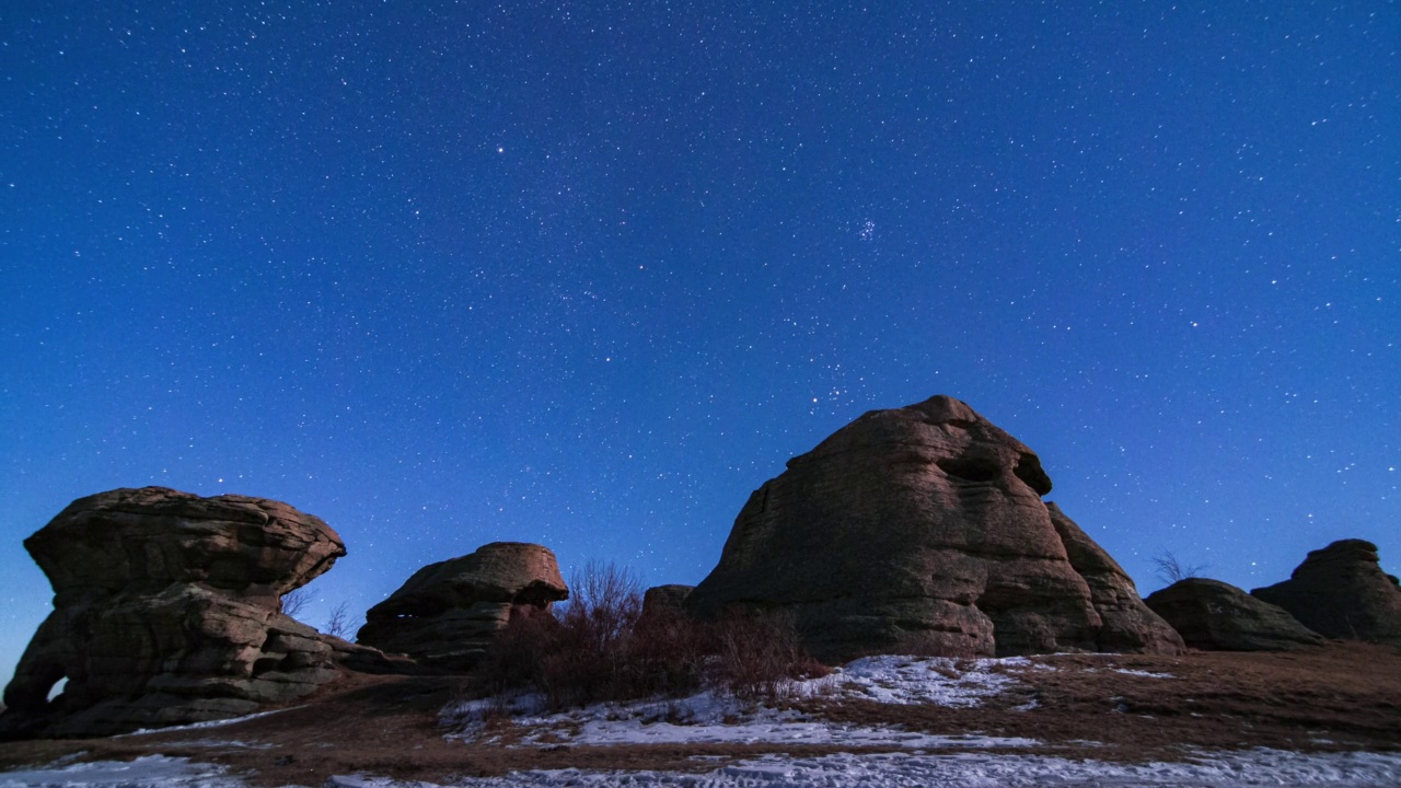 星星在岩石残骸上方的夜空中移动。高质量4k延时镜头视频素材