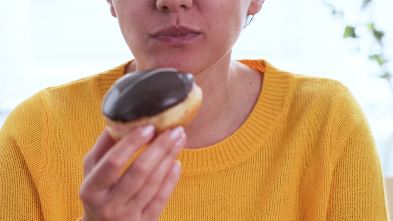 女人在家吃甜甜圈视频素材