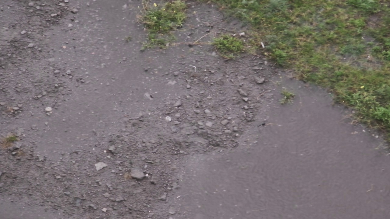 雨滴落在秋天街道泥泞的水坑慢动作视频素材