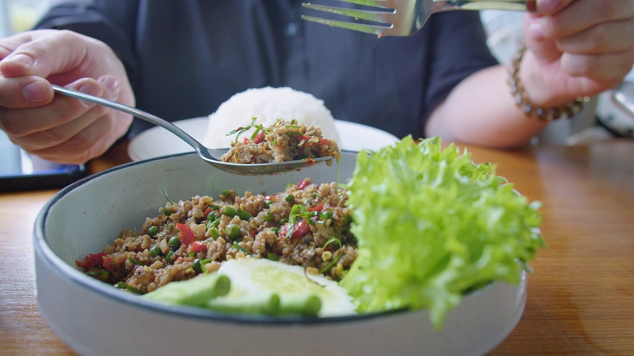 在餐馆的餐桌上，泰国罗勒拌猪肉末，配上茉莉饭视频素材