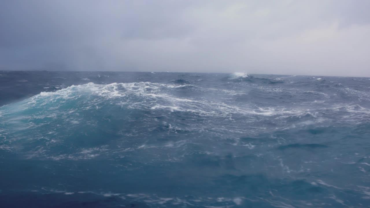 夕阳落在波涛汹涌的海面上，从一艘小船上驶过开阔的大海视频素材