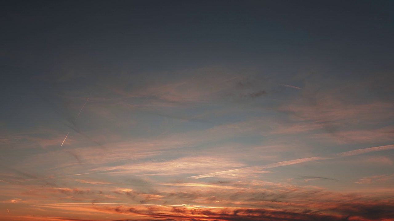 美丽的橙色的日落。乌云在色彩斑斓的夕阳下快速移动。绒毛云在夕阳黄昏黄昏，时光流逝。美丽的云景和天空的日落视频素材