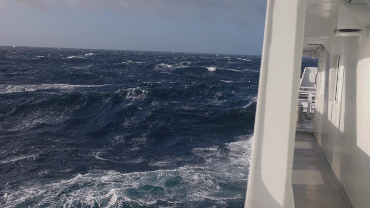 夕阳落在波涛汹涌的海面上，从一艘小船上驶过开阔的大海视频素材