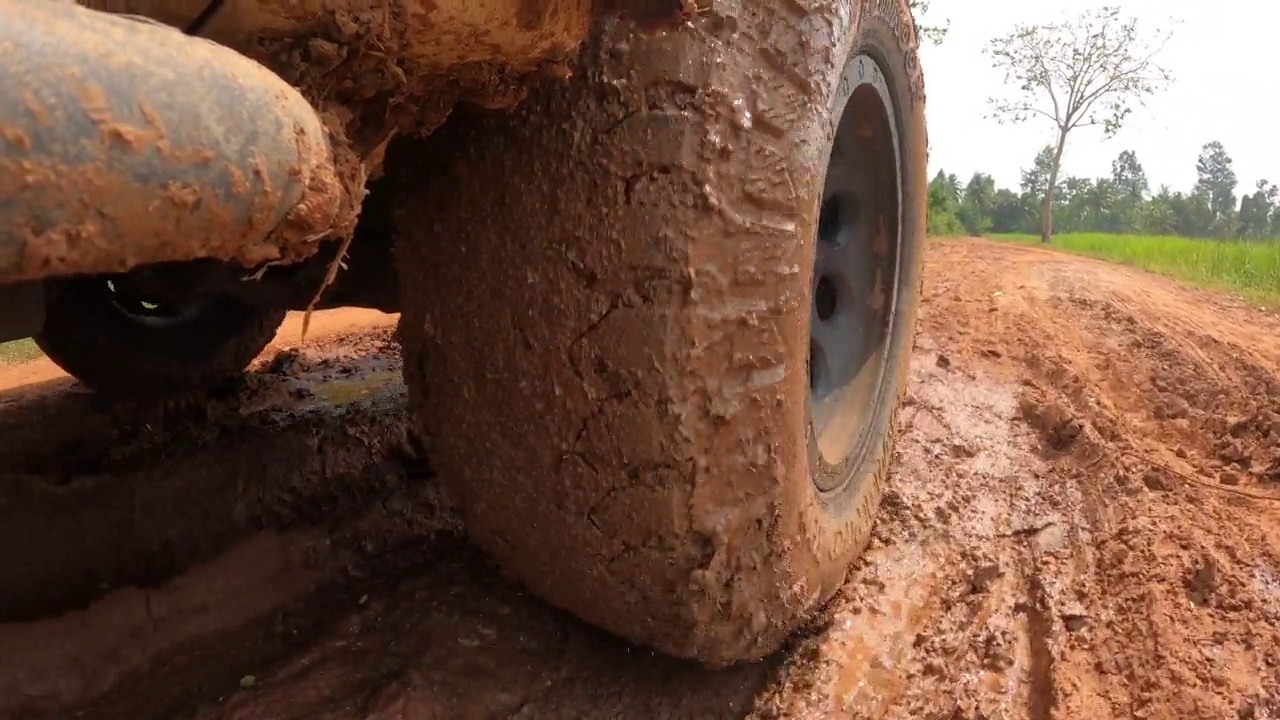 皮卡车的轮子在土路上奔跑。越野卡车汽车车轮在肮脏的道路上移动，带着灰尘、干湿泥浆。观点四驱卡车轮胎旅行在偏僻的地方视频素材