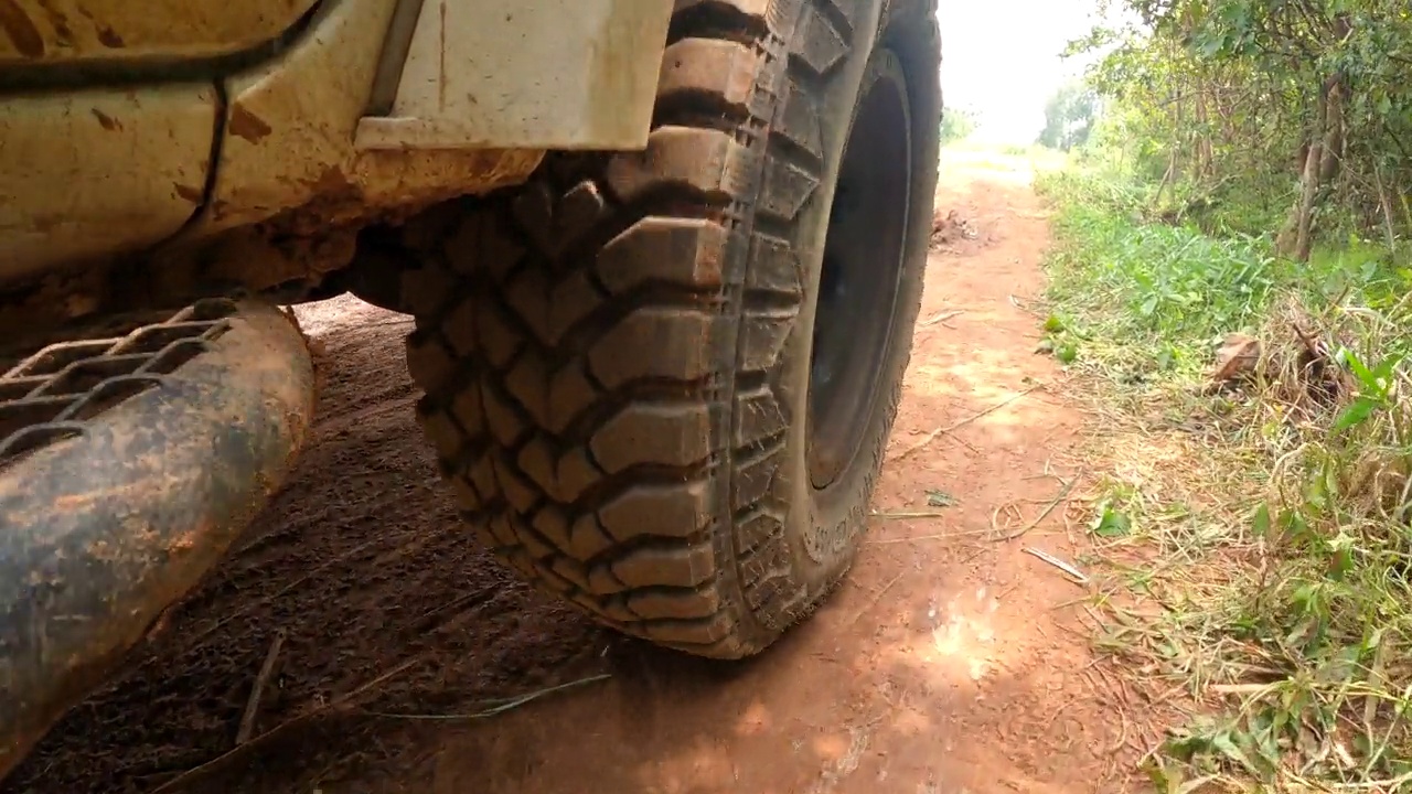 皮卡车的轮子在土路上奔跑。越野卡车汽车车轮在肮脏的道路上移动，带着灰尘、干湿泥浆。观点四驱卡车轮胎旅行在偏僻的地方视频素材