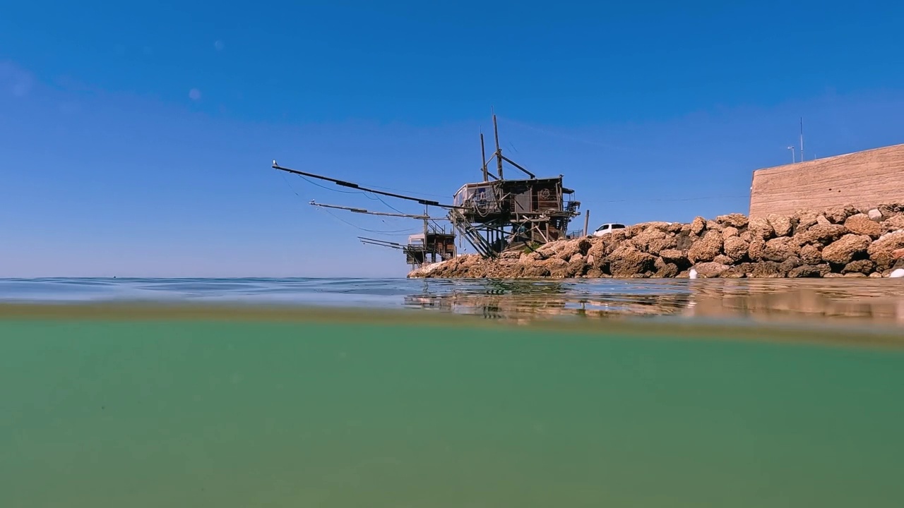 在意大利阿布鲁佐的Costa dei Trabocchi Punta Penna海滩上的trabucco或trabucco水下分割视图。低角度慢动作水面边缘视图视频素材