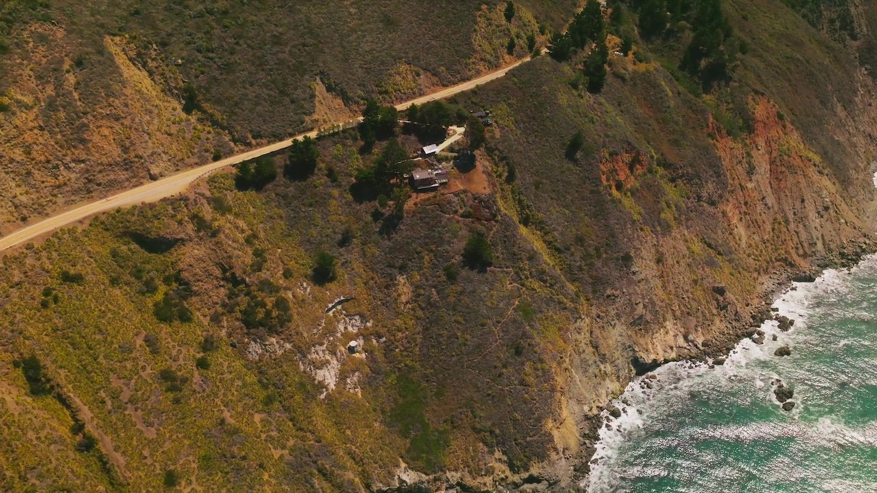 美国加利福尼亚州太平洋海岸倾斜山脉上的房屋景观。高速公路建在沿着海岸的山上。视频素材