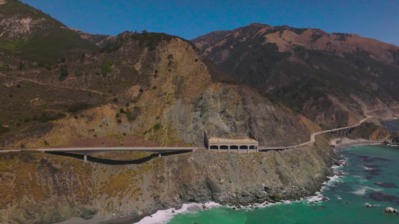 连接加州海岸线山脉的公路。在湛蓝晴空的背景下，崎岖的岩石是美丽的景色。视频素材