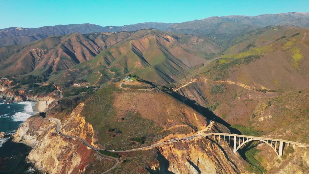 交通在山上的桥梁和公路上移动。阳光明媚的日子，太平洋海岸的加利福尼亚岩石海岸。前视图。视频素材