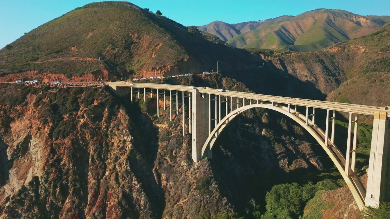 繁忙的道路绕过崎岖的山峦，穿过美丽的拱桥，越过岩石的缝隙。蓝天为背景。前视图。视频素材