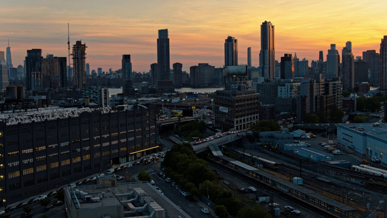 从长岛市的地铁可以看到布鲁克林绿点区(Greenpoint)的建筑建设和猎人角(Hunters Point)的豪华公寓。东河上的曼哈顿，日落时自由塔清晰可见。航拍镜头向前平移运动。视频素材