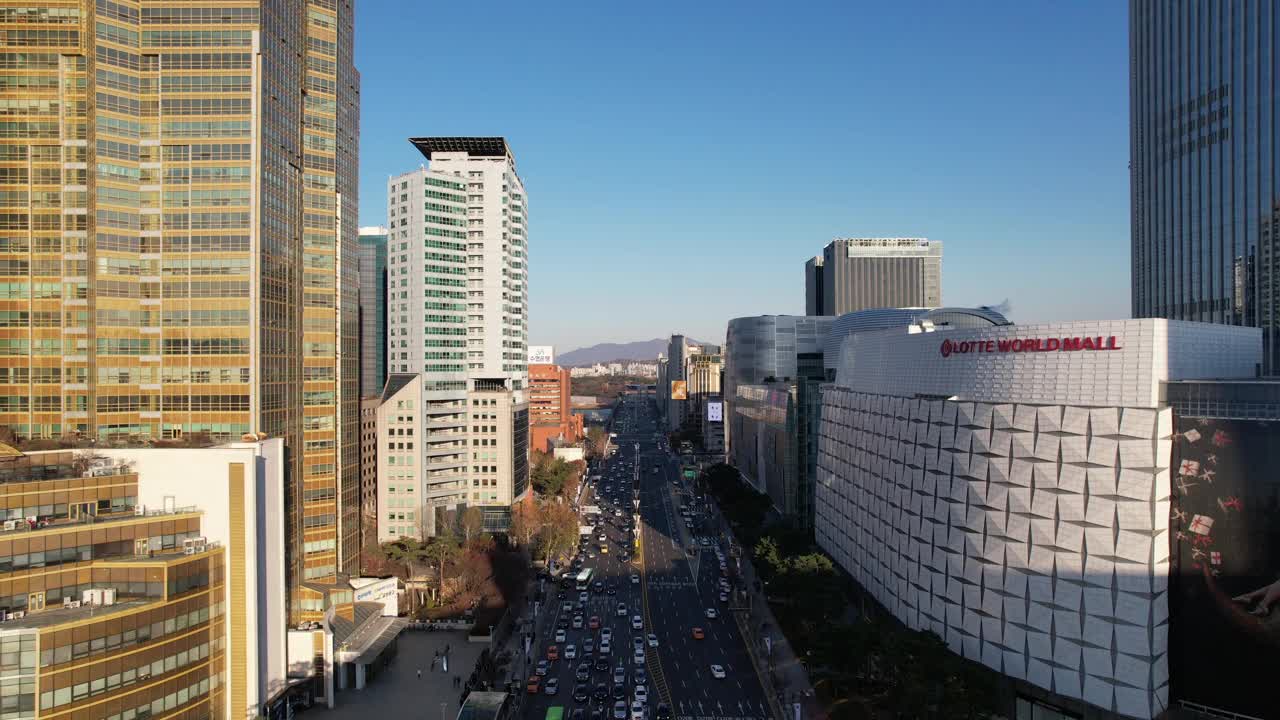 韩国首尔，蚕室区/松坡区，乐天世界大厦附近的城市景观和蚕室(松坡区办事处)站的交叉口视频素材