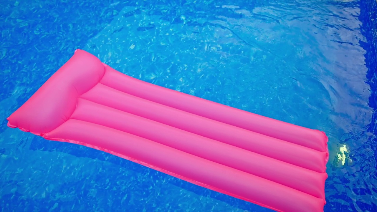 粉红色的游泳垫在粉红色的水面上移动。游泳池里的充气床垫。前视图。视频素材