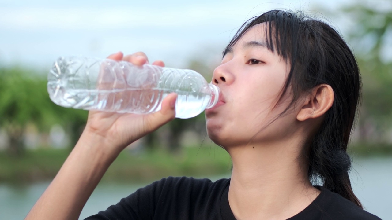 亚洲妇女做跑步和饮酒活动视频素材