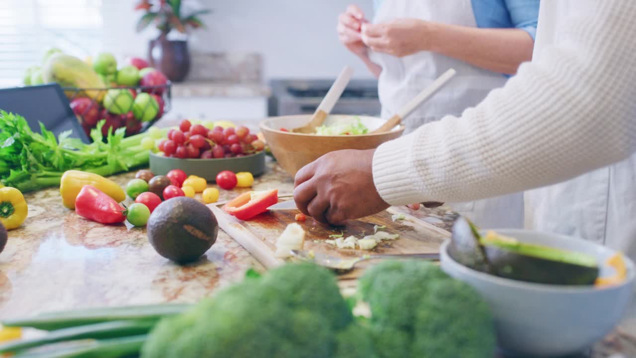 美食、养生和老夫妇一起在家里的厨房里做饭，粘在一起准备营养、健康的餐点。跨种族的夫妻享受退休生活和平衡的饮食生活方式视频素材