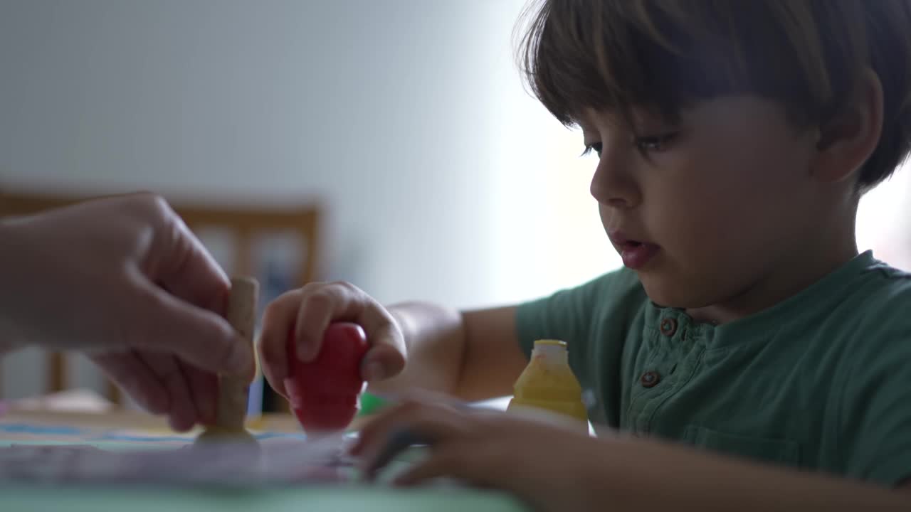 一个小男孩在家里用彩色画笔画画。儿童在家中进行创造性艺术活动。孩子着色视频素材