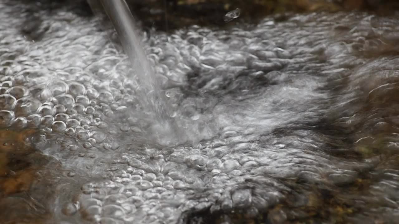 冬天有气泡的天然泉水。雨和冬天的概念。高质量全高清镜头视频素材