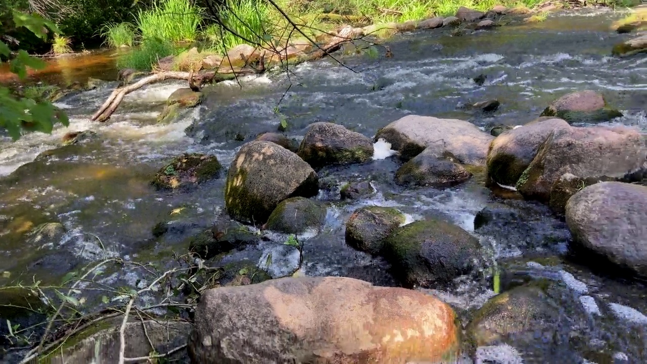 瀑布来自野生河流。山间河流有瀑布，水中有石头。视频素材