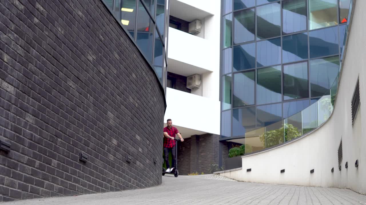 迷人的男子骑着电动摩托车在城市景观背景。视频素材