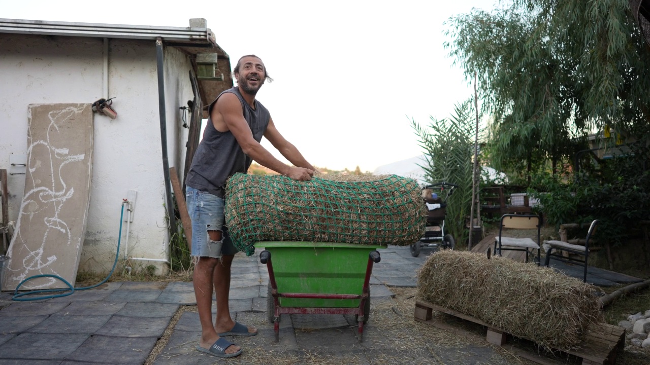 马场的农场工人用网盖住干草视频素材