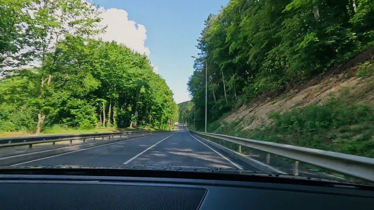 在森林的道路上看汽车。视角:汽车司机在森林中的道路上。视频素材