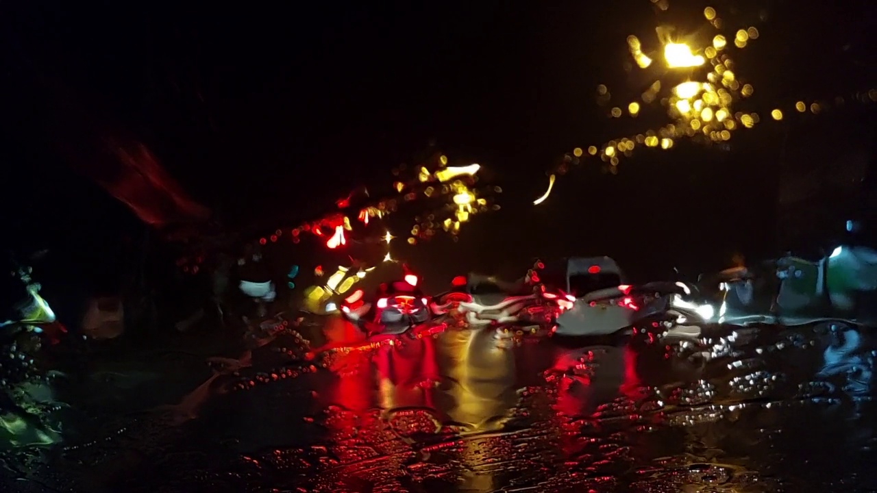 从挡风玻璃上看，汽车在大雨中行驶在路上。视频素材