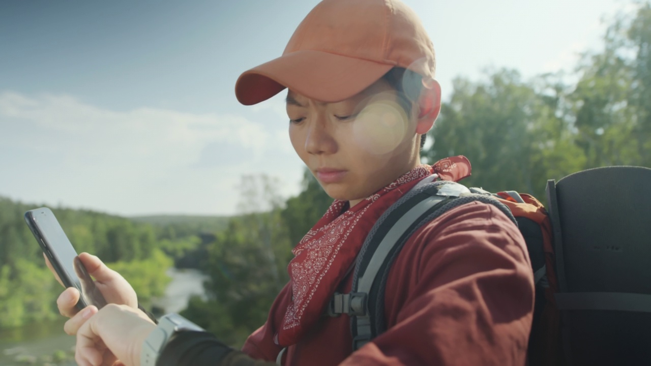 女性徒步旅行者使用手机和智能手表视频素材