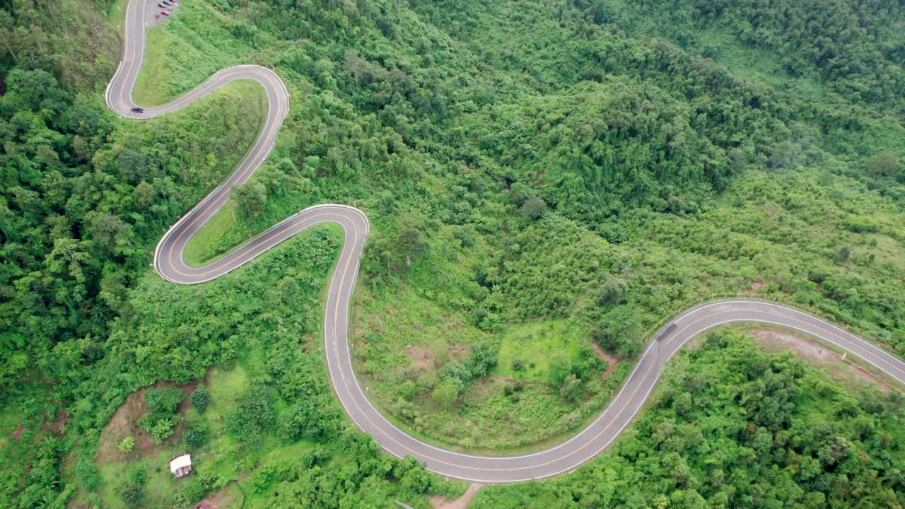 乡村道路穿过绿林和山峦的俯视图视频素材