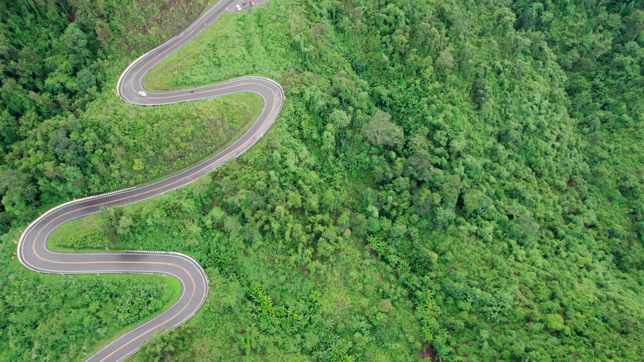 乡村道路穿过绿林和山峦的俯视图视频素材