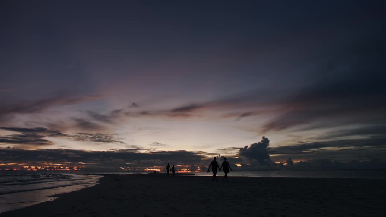 人们走在海滩上的夕阳剪影/马尔代夫视频素材