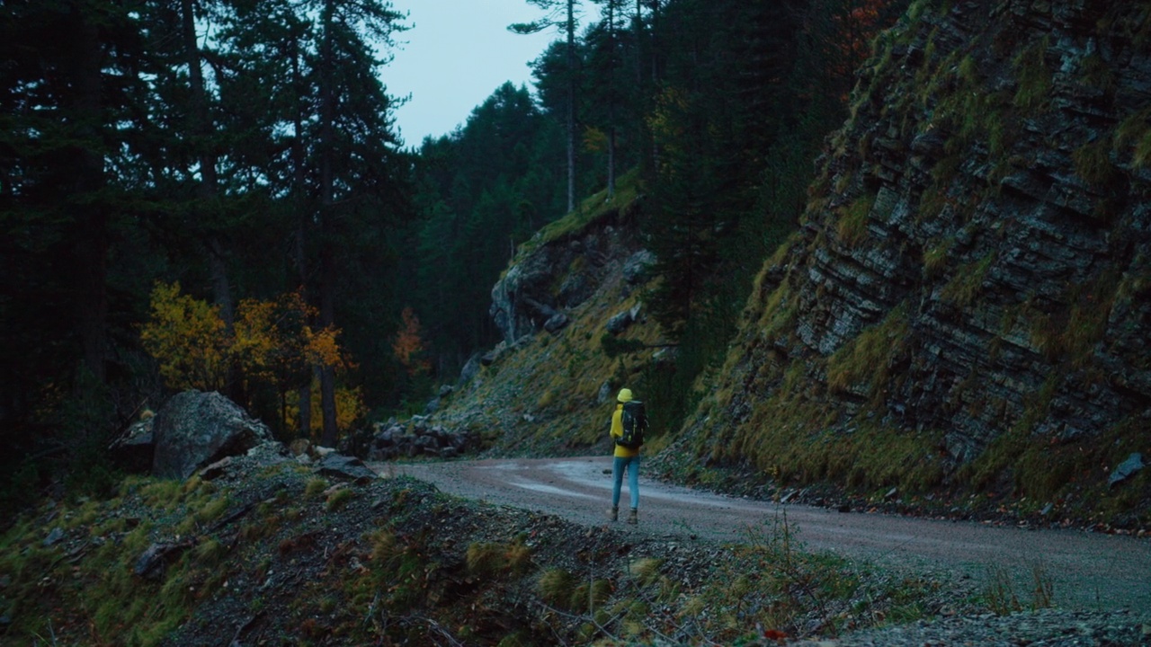 阴天的深夜，女人走在度假旅行的山路上视频素材