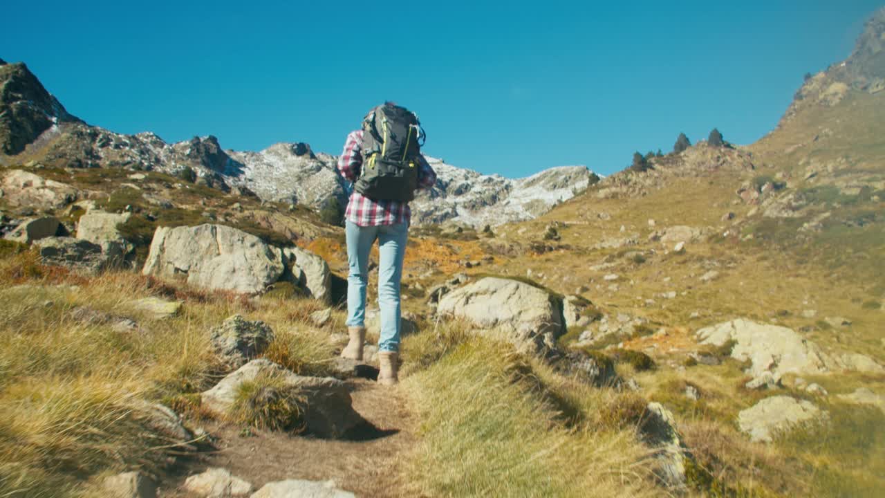 跟随背包客在阳光明媚的日子进行山地度假之旅，并享受其中视频素材