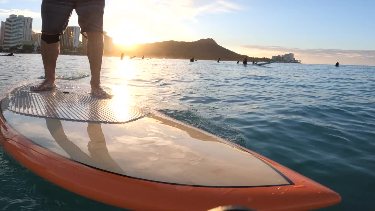 钻石头腿和脚SUP站起来冲浪冲浪POV在橙色冲浪板，檀香山，瓦胡岛，夏威夷。视频素材