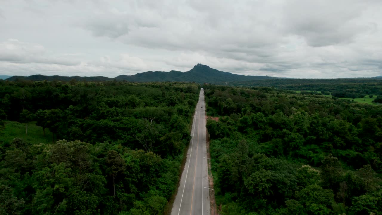 乡村道路穿过绿林和山峦的俯视图视频素材