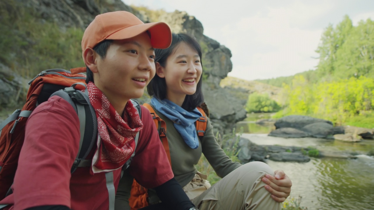 亚洲女性徒步旅行者在河岸上交谈视频素材