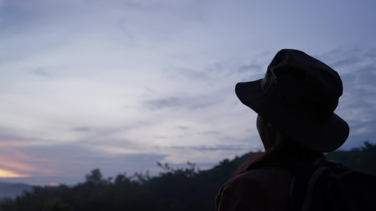 年轻女子望着山上美丽的天空。视频素材