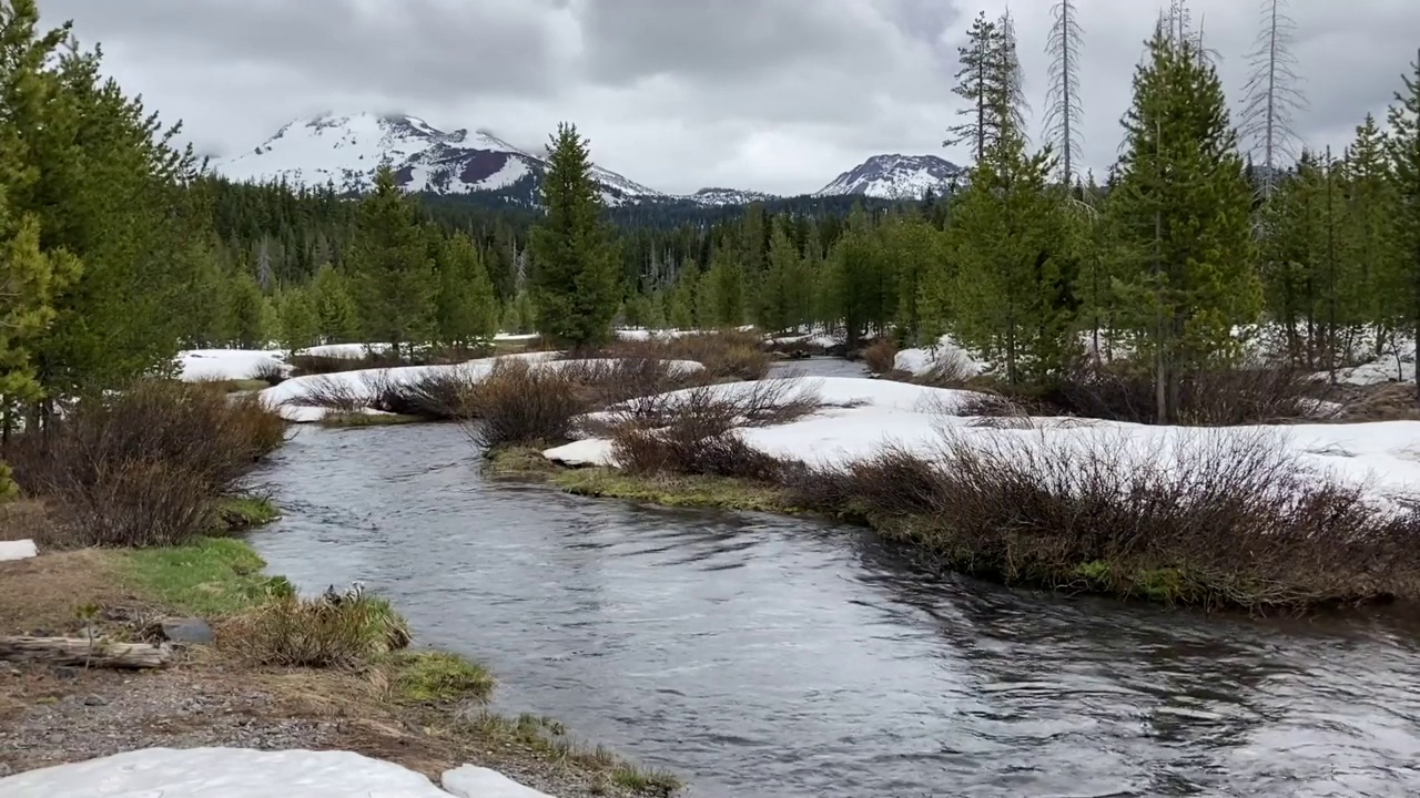 流淌的河流与俄勒冈喀斯喀特白雪皑皑的学士山的景色视频素材