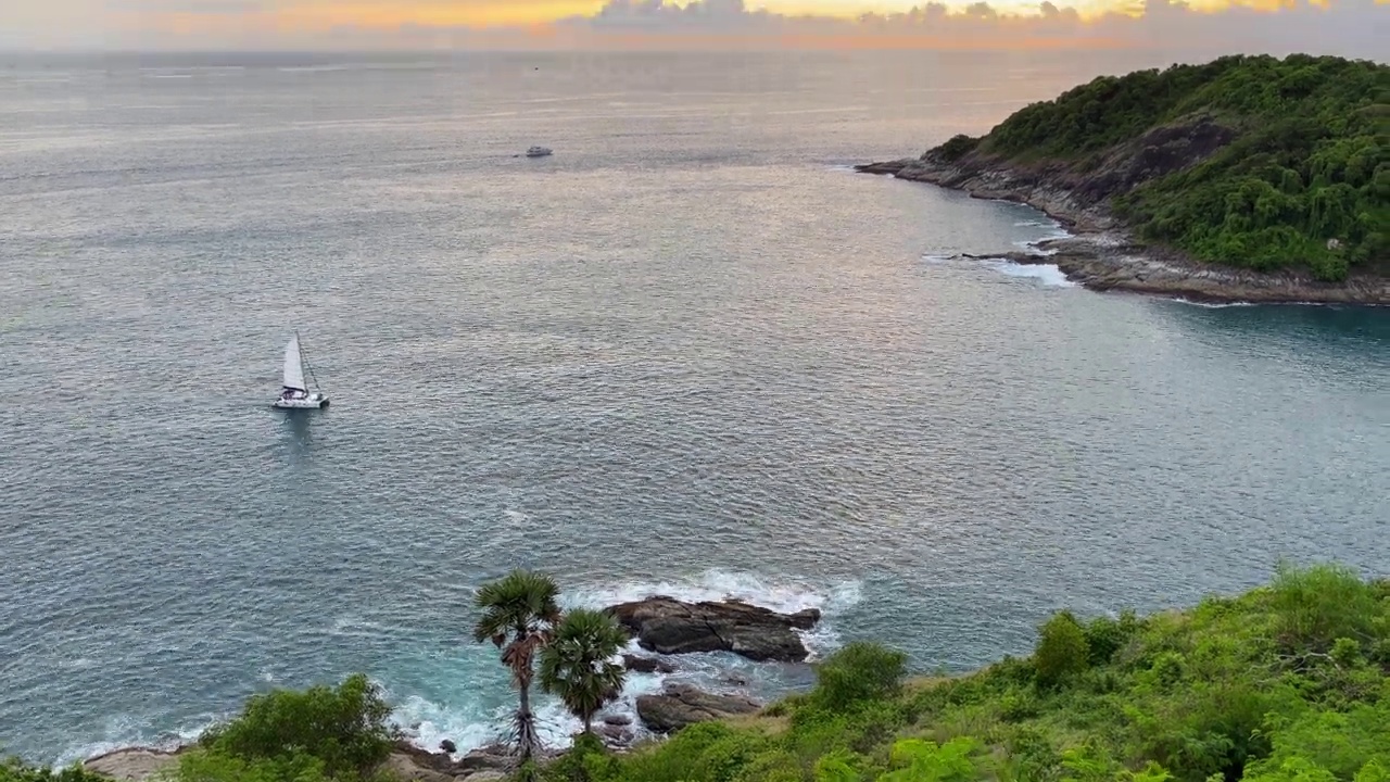 航海船航行在风平浪静的日落在Promthep斗篷,普吉岛视频素材