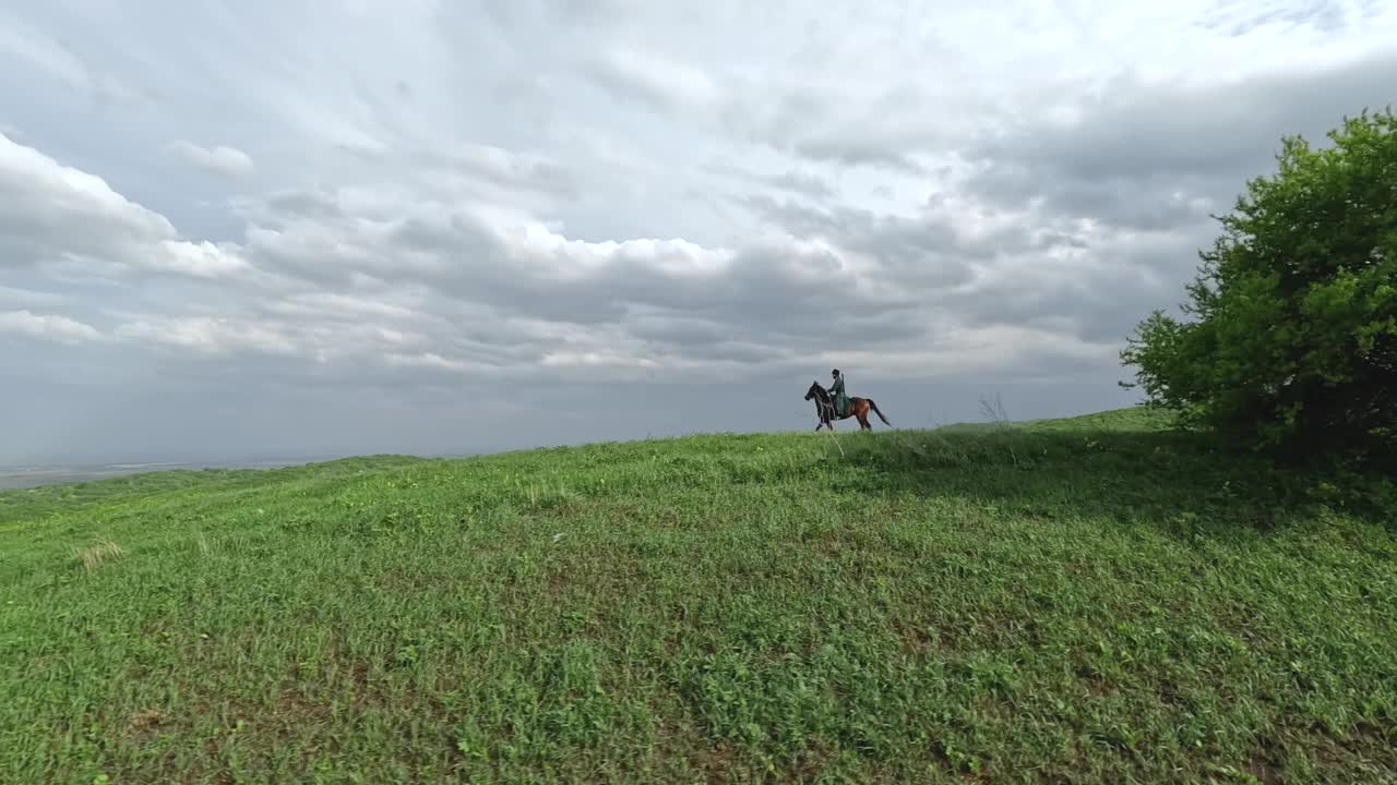 空中全景白种人穿着传统服装骑在碎石路上的马视频素材