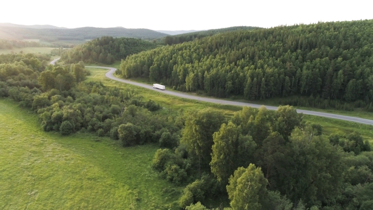 夏天卡车行驶在高速公路上的全景。行动。美丽的夏日风景，绿树成荫，卡车行驶在高速公路上。夏天的一天，卡车行驶在乡村公路上视频素材