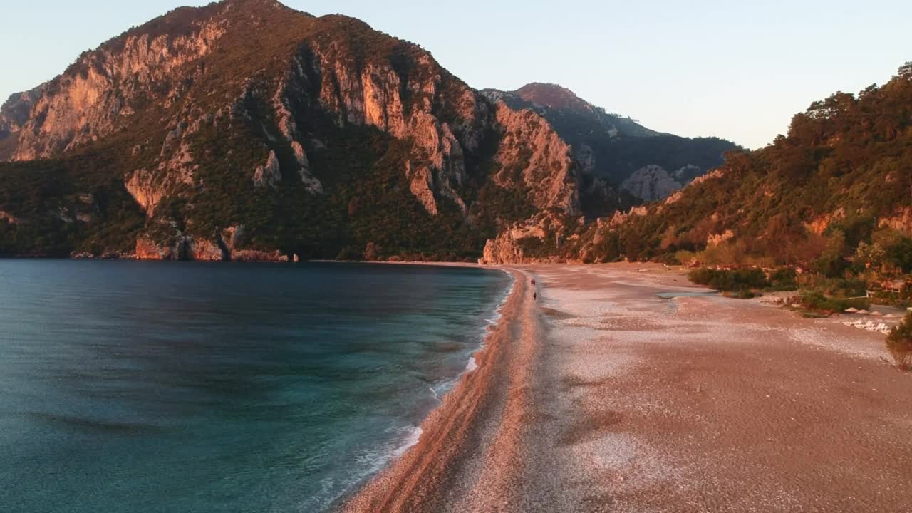 在落日的余晖中，从高空俯瞰西拉利海滩和奥林波斯山。凯默，安塔利亚，地中海地区，土耳其，莱西亚。视频素材